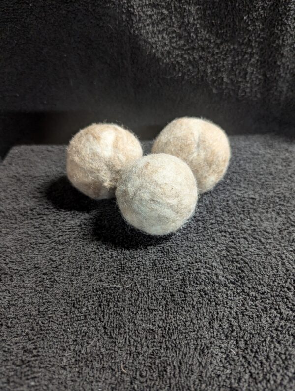 Three balls of soap sitting on top of a towel.