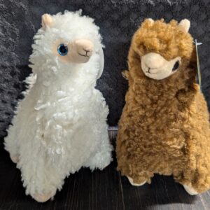 Two stuffed animals one is white and the other brown