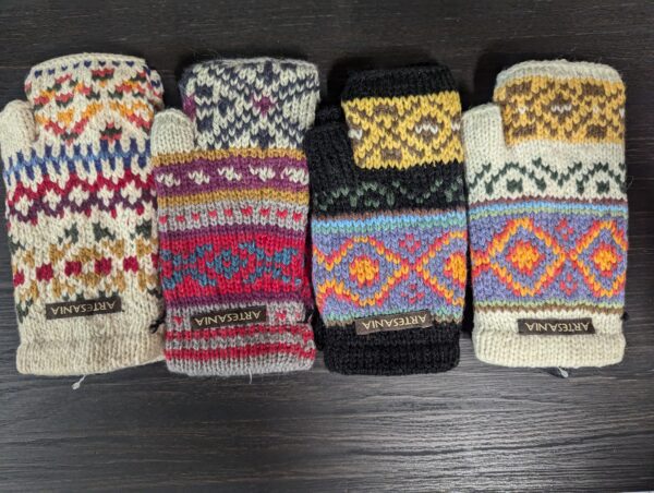 A group of four different colored mittens sitting on top of a table.